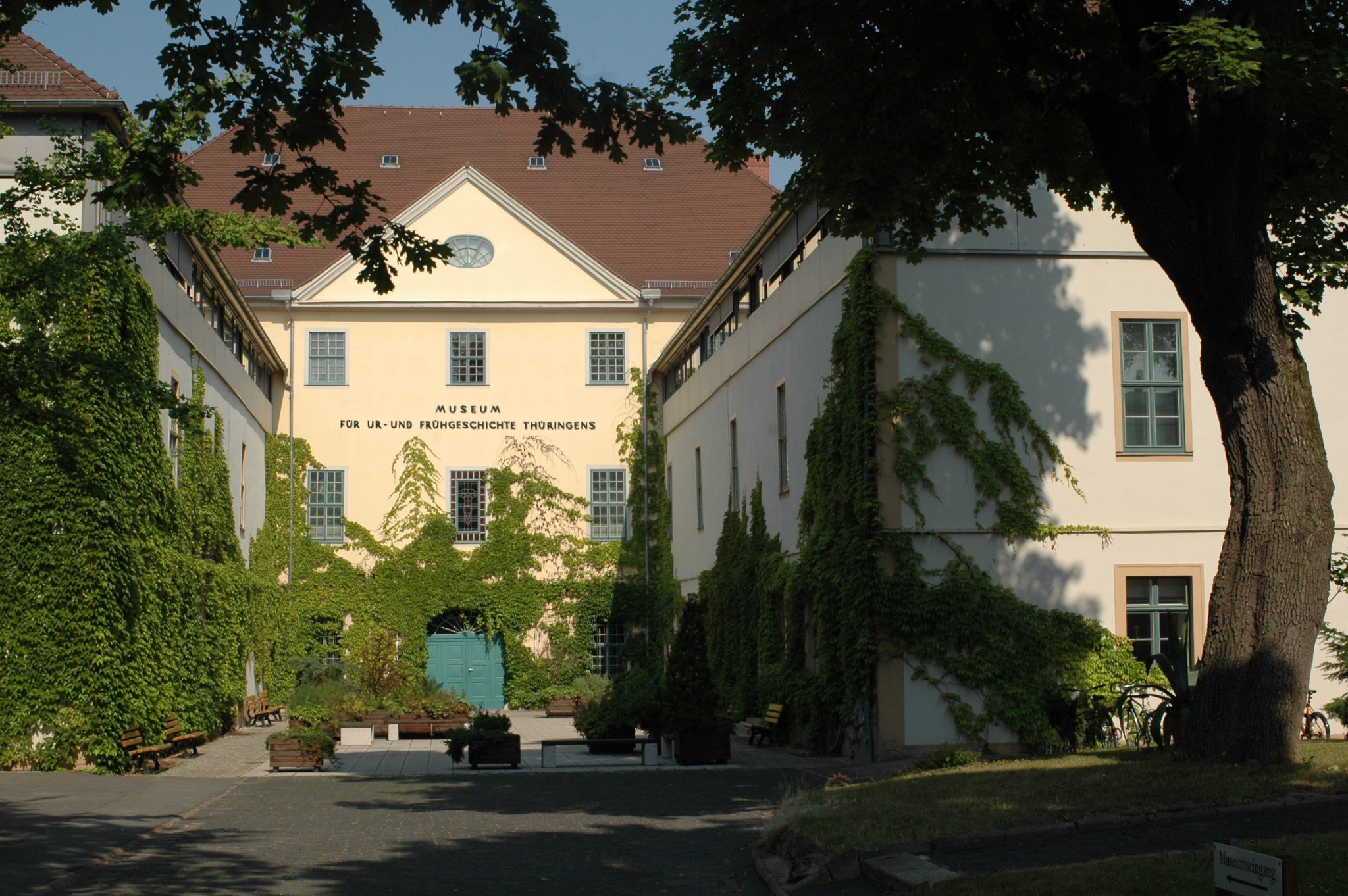 Blick in den Museumshof des dreiflügligen Gebäudes mit grün bewachsener Fassade