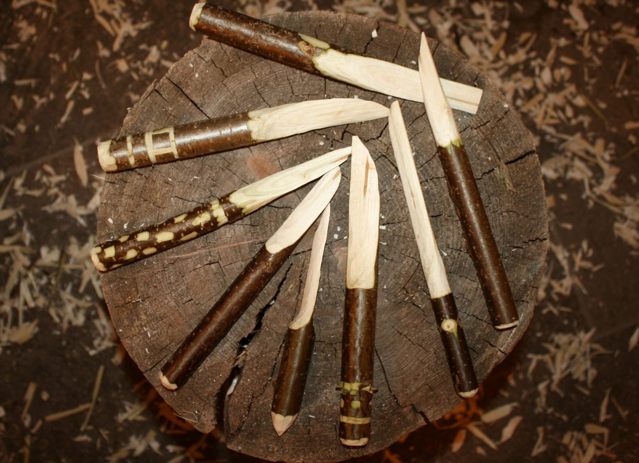Selbstgeschnitzte Messer aus Holz, die in einem Kreis angeordnet sind.